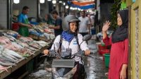 Perempuan memakai sepeda motor untuk ojek menjadi lebih berdaya dengan program Mekaar dari PT PNM Perempuan-Perempuan yang Bertahan di Tengah Keterbatasan, PNM Buka Jalan Kemandirian